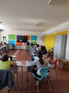 ragazzi al computer seduti ai banchi disposti a ferro di cavallo