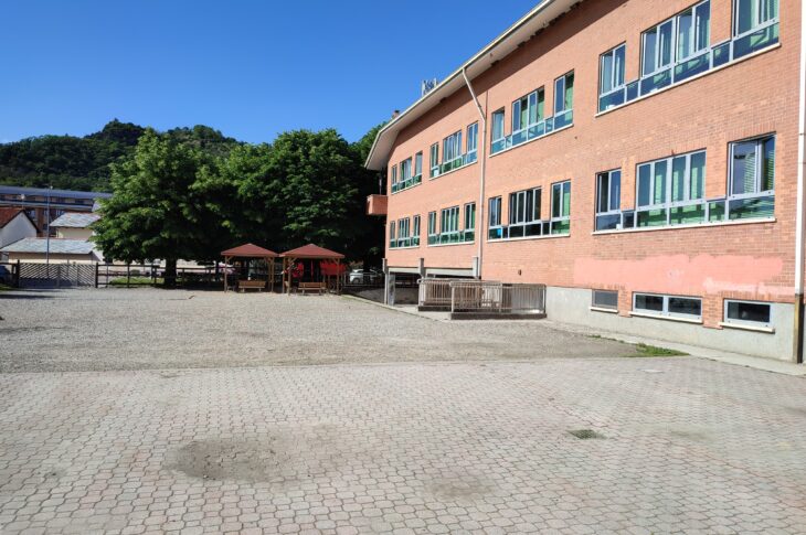 esterno della scuola secondaria di primo grado Cavour. Davanti alla scuola c'è un ampio piazziale e la scuola ha le pareti esterne fatte di mattoncino di colore arancio mattone