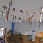 l'immagine è una foto di una sala interna della scuola primaria di cavour, con appesi sul soffitto degli aquiloni di carta piccoli