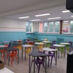 aula della scuola secondaria di primo grado di villafranca con lavagna interattiva, pareti bianche e azzurre e banchi con sedie di vari colori