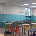 aula della scuola secondaria di primo grado di villafranca con lavagna interattiva, pareti bianche e azzurre e banchi con sedie di vari colori