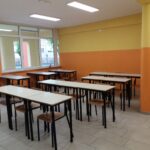aula della scuola secondaria di primo grado di villafranca con lavagna interattiva, pareti gialle ed arancioni e banchi con sedie di vari colori